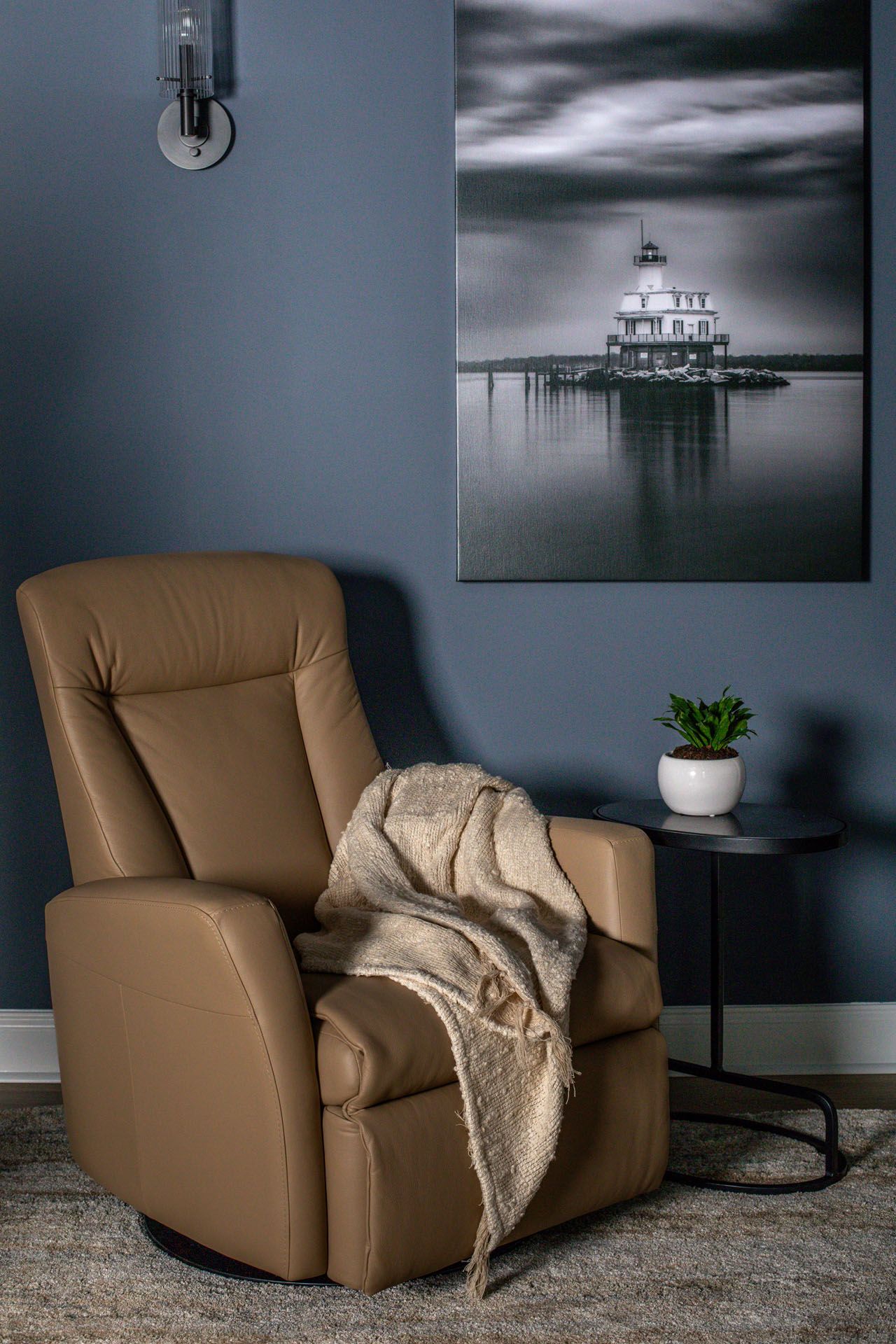 A chair with a blanket on it is sitting in a living room next to a table.