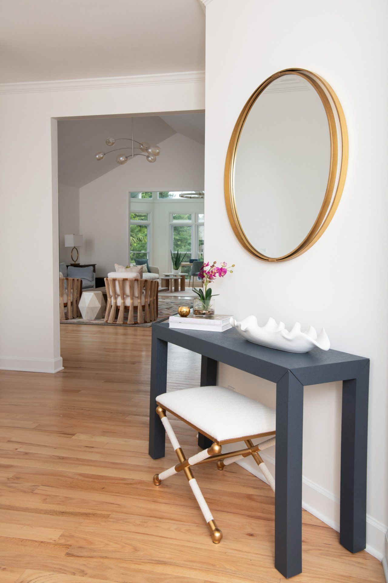 Entryway with a navy console table, gold-framed mirror, and white and gold bench | Charlotte, NC | An Inspiring Home