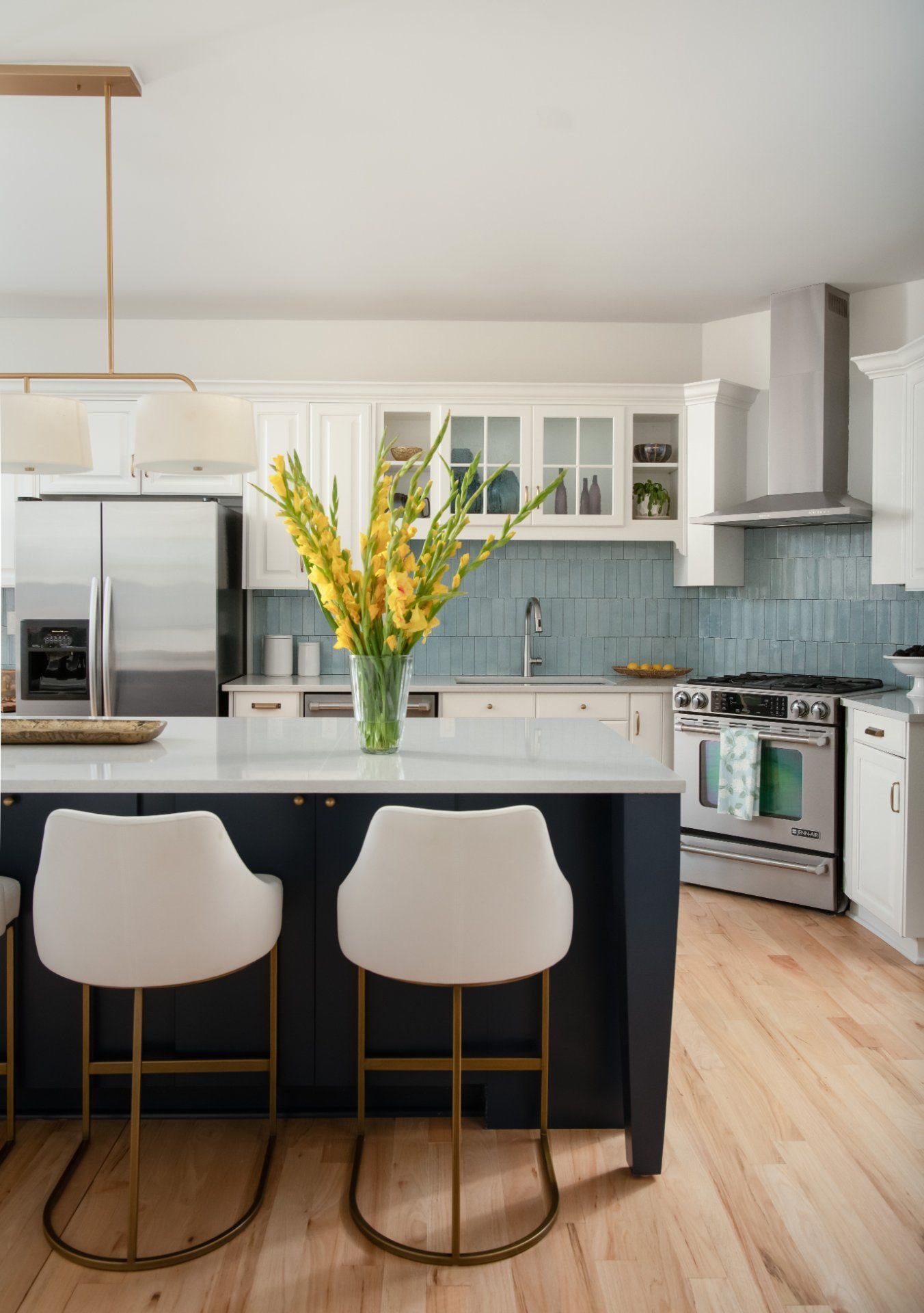 Modern kitchen with a blue backsplash, white cabinets, navy island, and yellow flowers | Charlotte, NC | An Inspiring Home