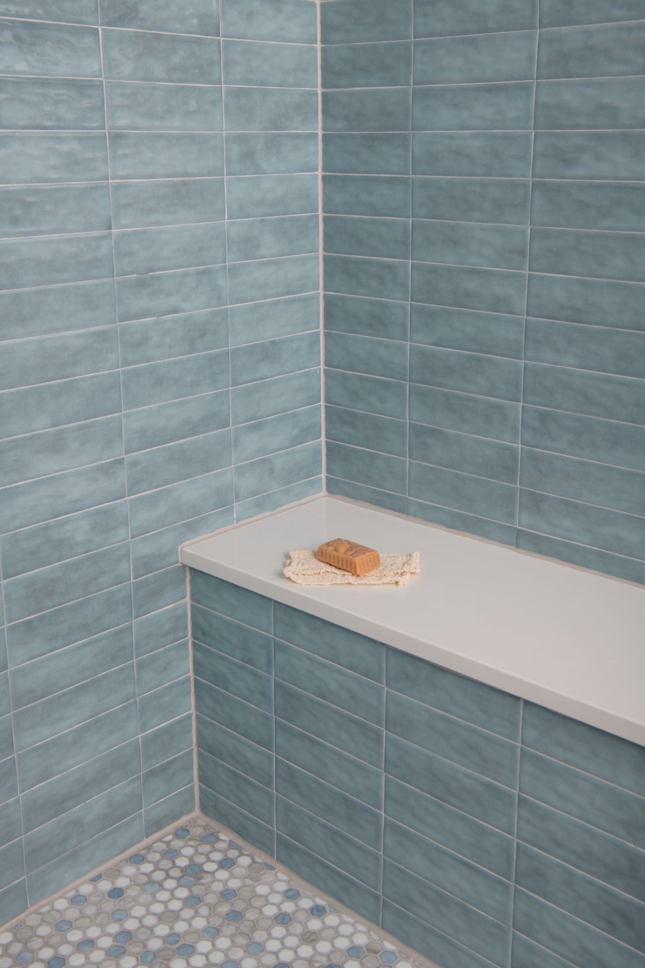 Blue tiled shower with a white bench, and a bar of soap | Charlotte, NC | An Inspiring Home