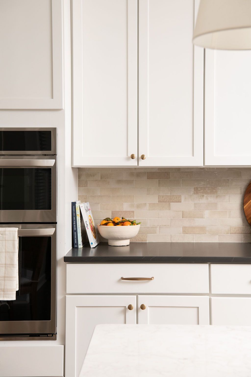 There is a bowl of fruit on the counter in the kitchen.