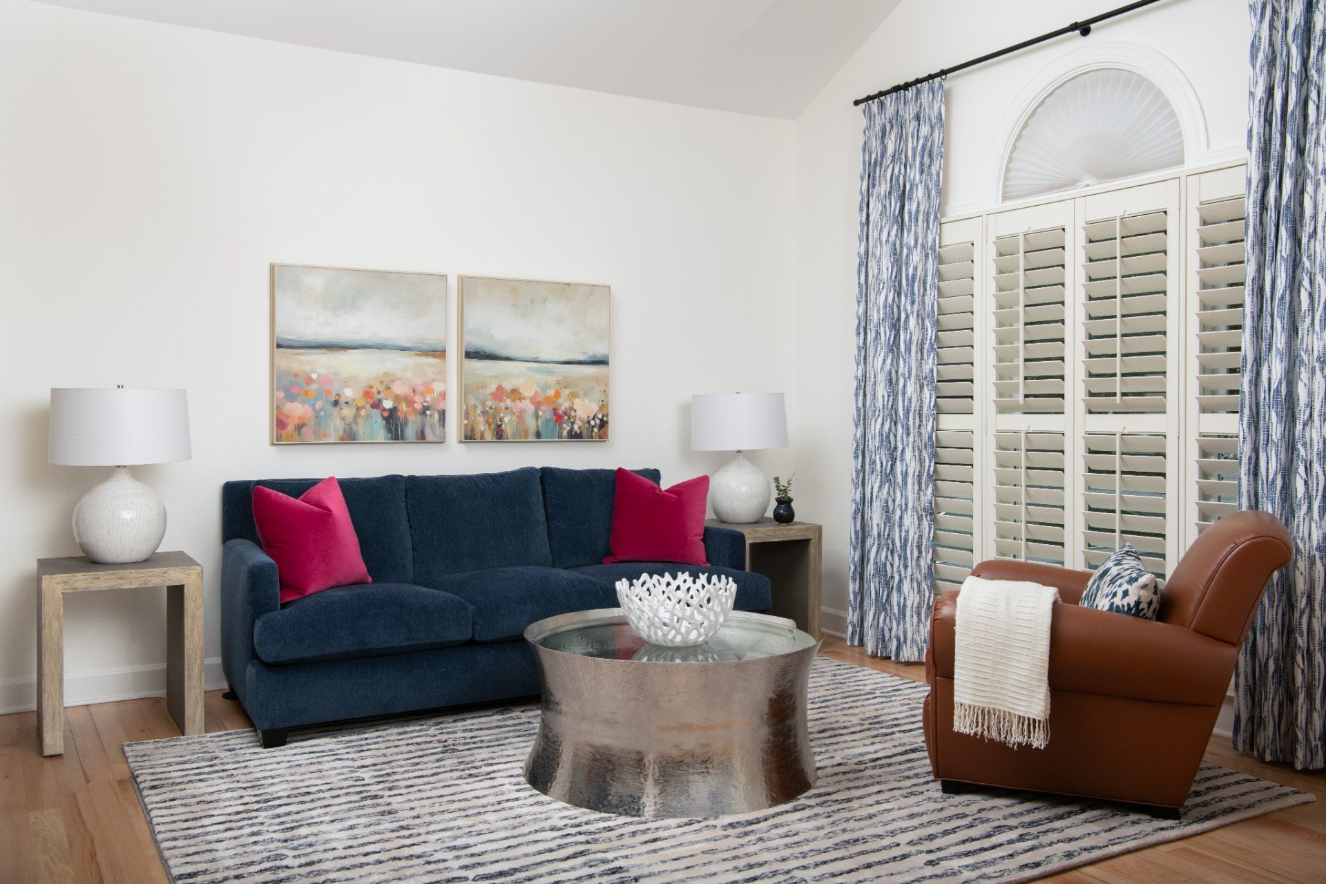 Living room with blue sofa, pink pillows, brown chair, and silver coffee table | Charlotte, NC | An Inspiring Home