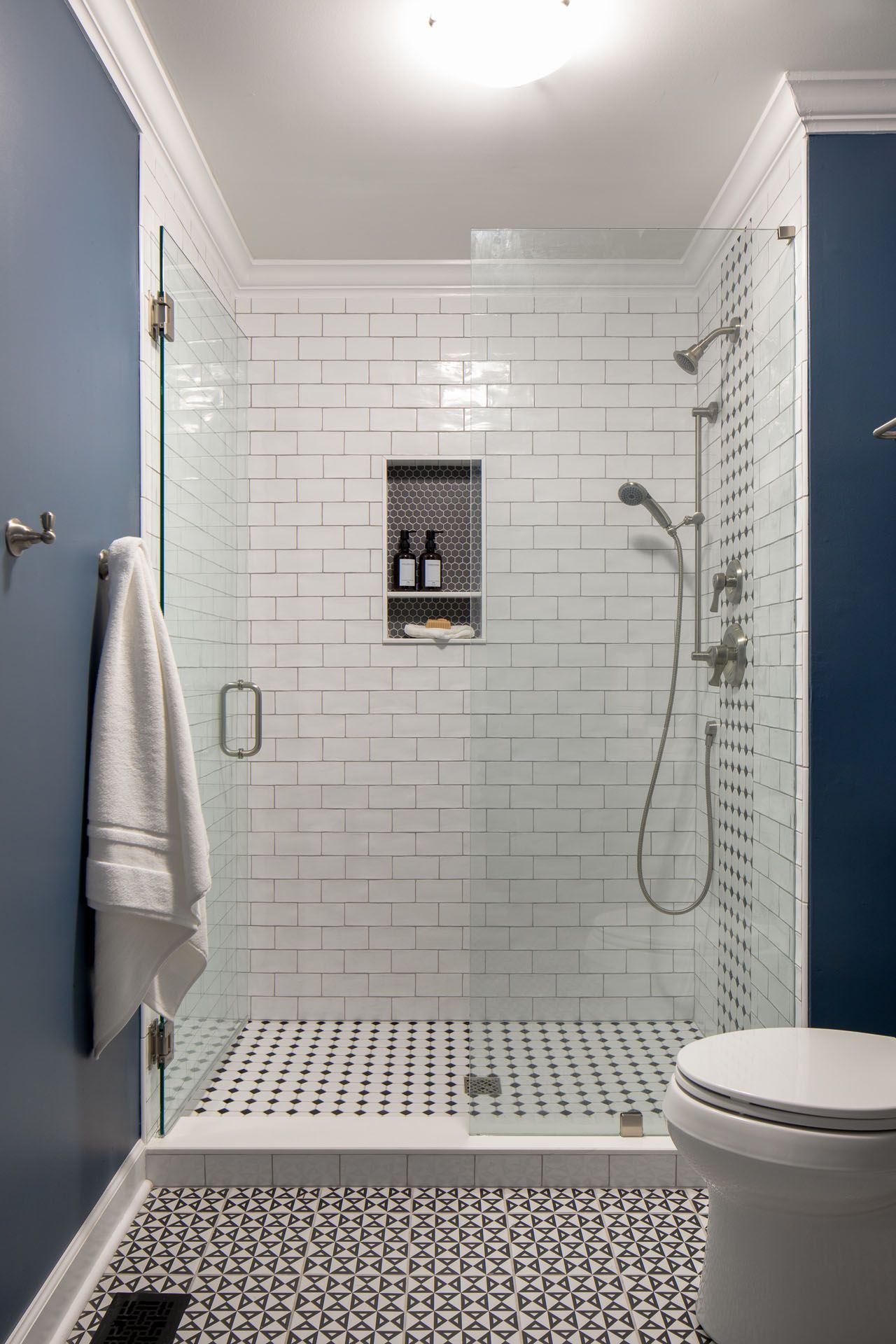 A bathroom with a walk in shower and a toilet.