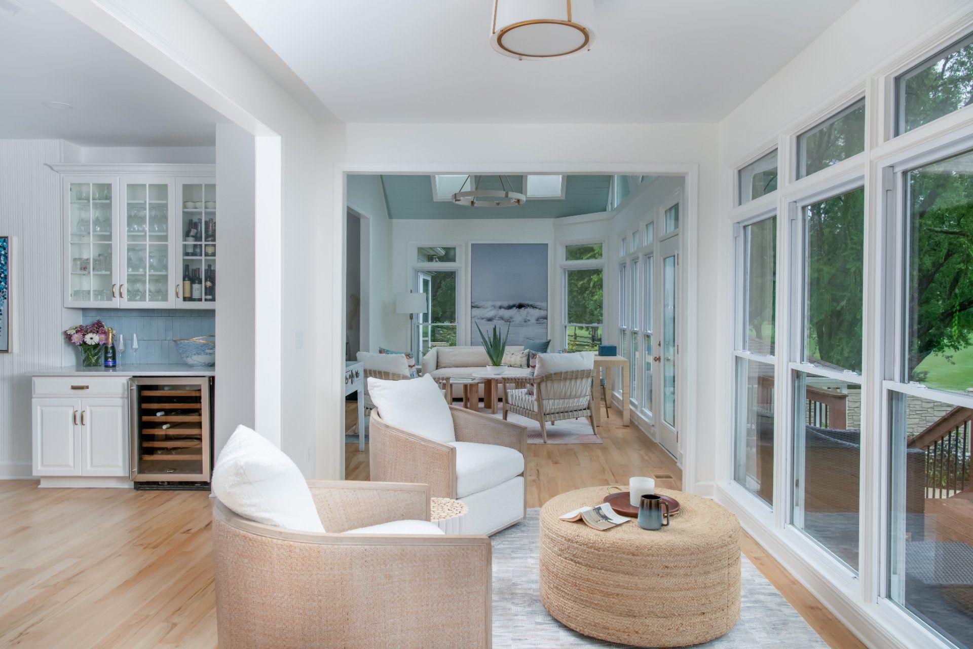 Bright, airy interior with white walls, cozy seating, and a view of a light-filled sunroom | Charlotte, NC | An Inspiring Home