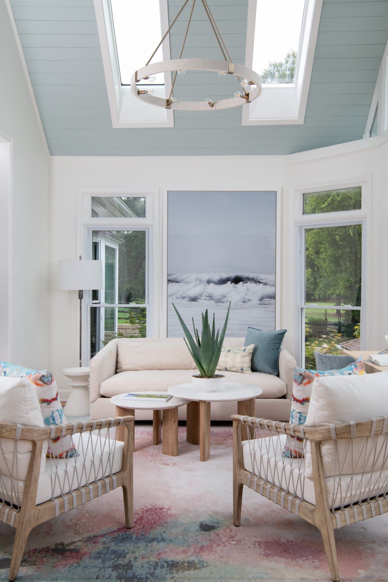 Bright sunroom with light blue ceiling, skylights, white walls, sofa, chairs, and colorful rug | Charlotte, NC | An Inspiring Home