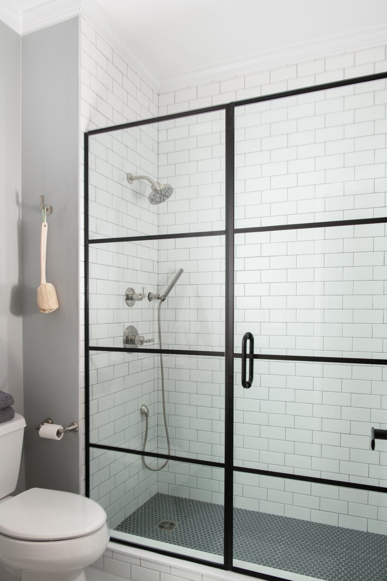 Bathroom with a black-framed glass shower enclosure, white subway tile, and a toilet | Charlotte, NC | An Inspiring Home