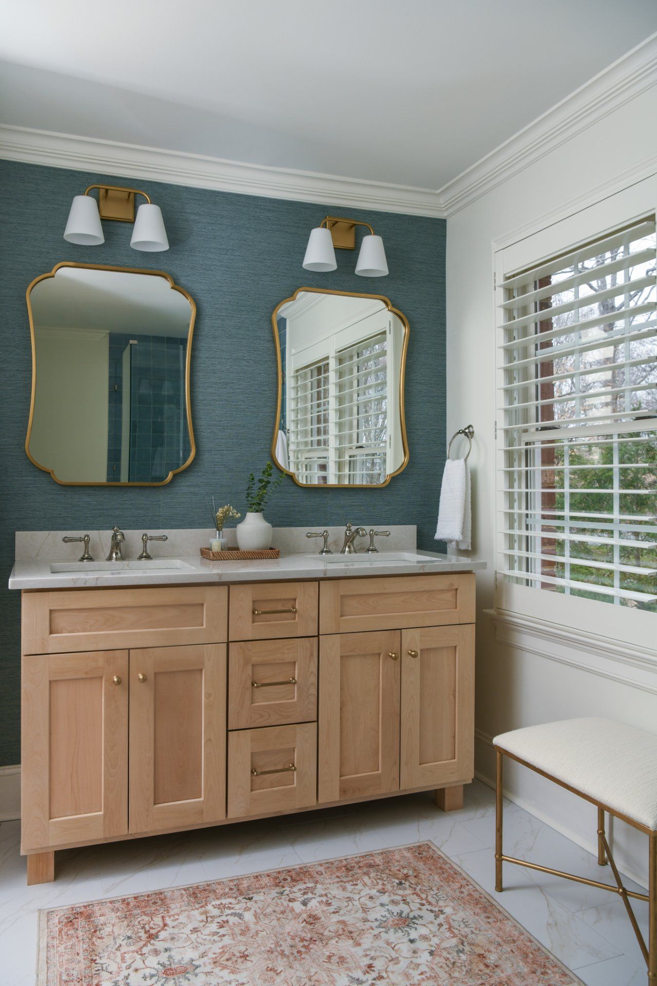 Blue bathroom with wood vanity, twin mirrors, white shutters, and a patterned rug | Weddington, NC | An Inspiring Home