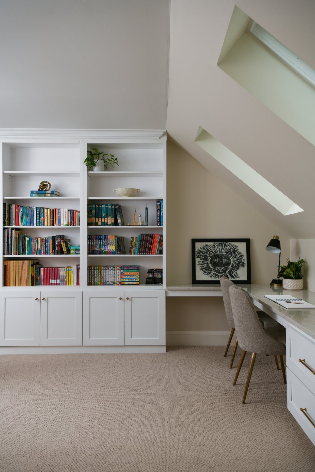 Modern home office with white bookshelves, desk, chairs, and skylights in a beige room | Weddington, NC | An Inspiring Home