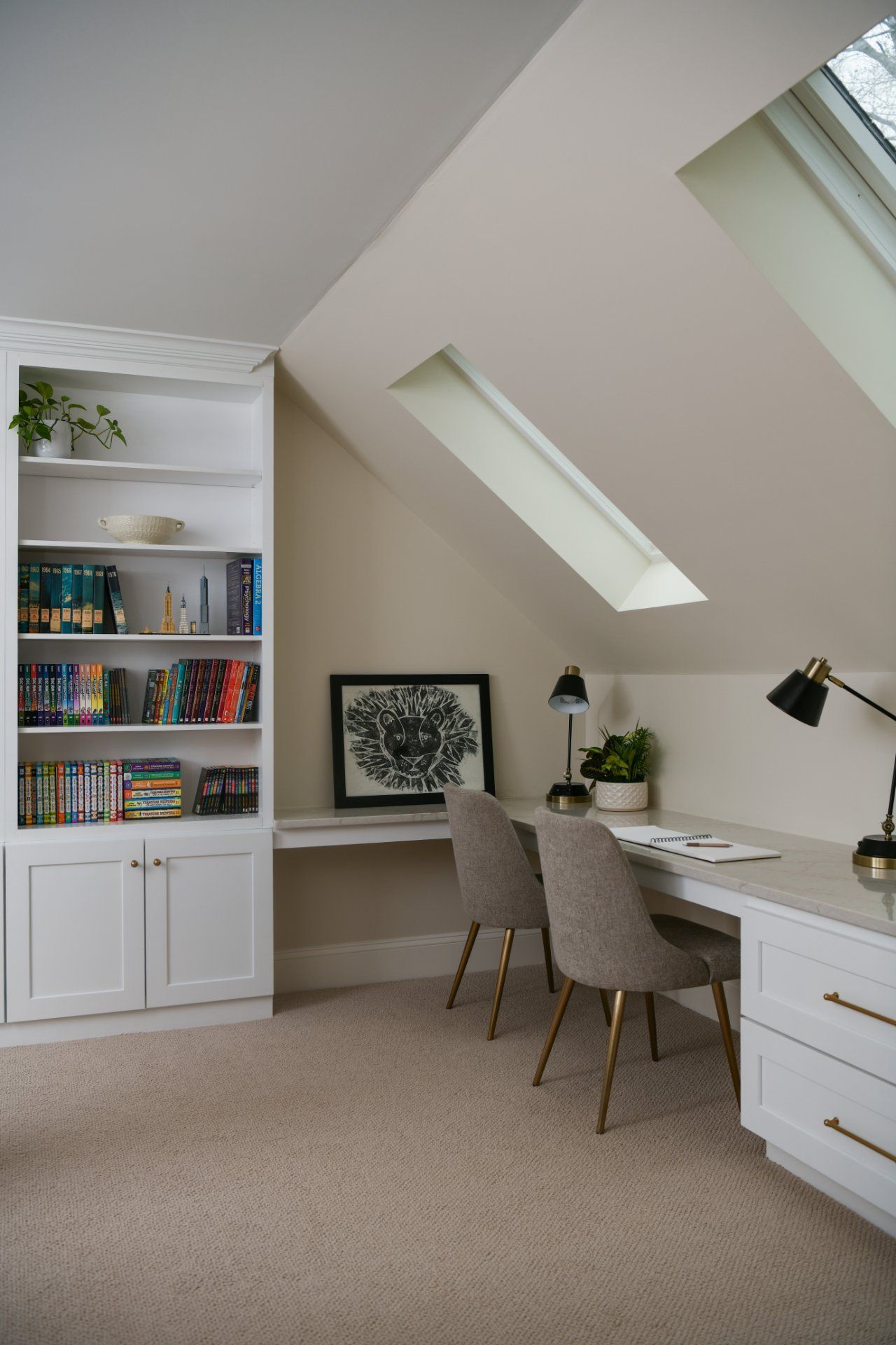 Bright home office with white desk, gray chairs, bookshelf, and slanted skylight windows | Weddington, NC | An Inspiring Home