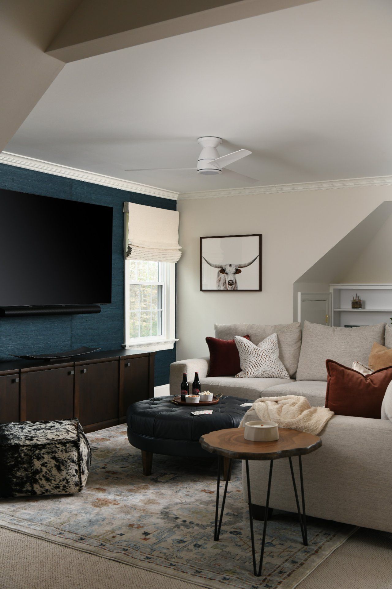 Cozy living room with gray sectional, dark TV cabinet, patterned rug, and geometric wall art | Weddington, NC | An Inspiring Home