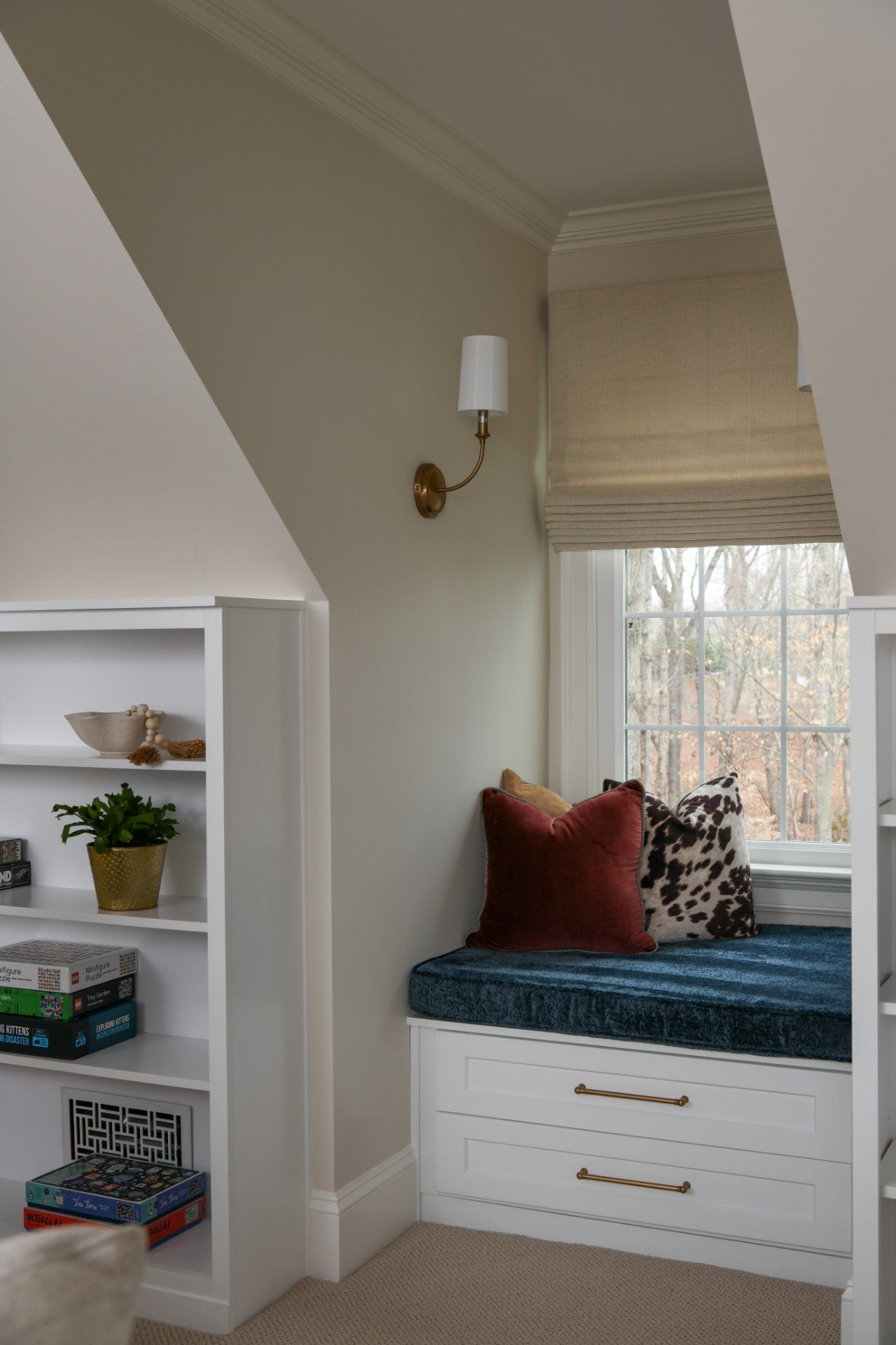 Built-in window seat with teal cushion and pillows in a light beige room | Weddington, NC | An Inspiring Home