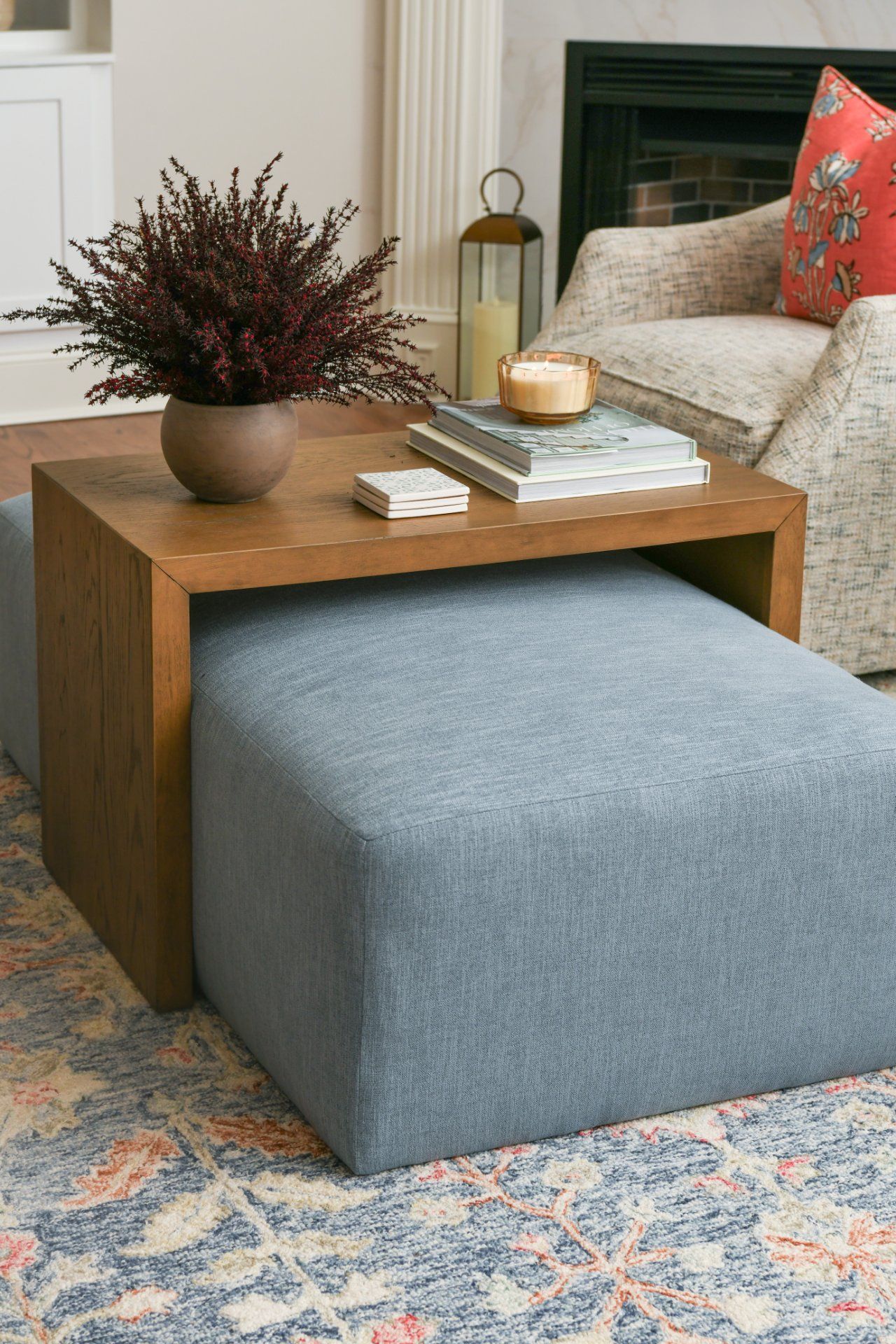 Blue ottoman with wooden tray, books, candle, and vase of flowers in a cozy living room | Weddington, NC | An Inspiring Home