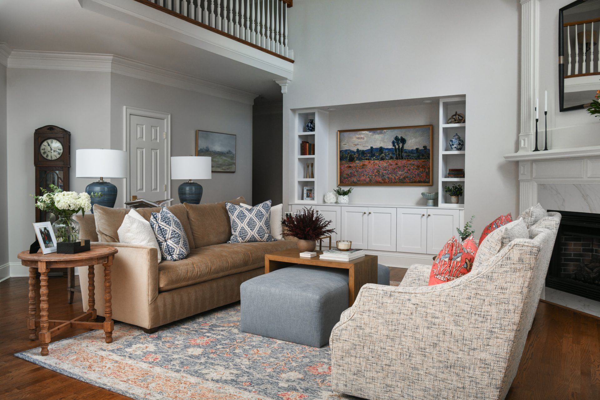 Bright living room with tan sofa, patterned chair, ottoman, and built-in shelving under a lofted ceiling | Weddington, NC | An Inspiring Home