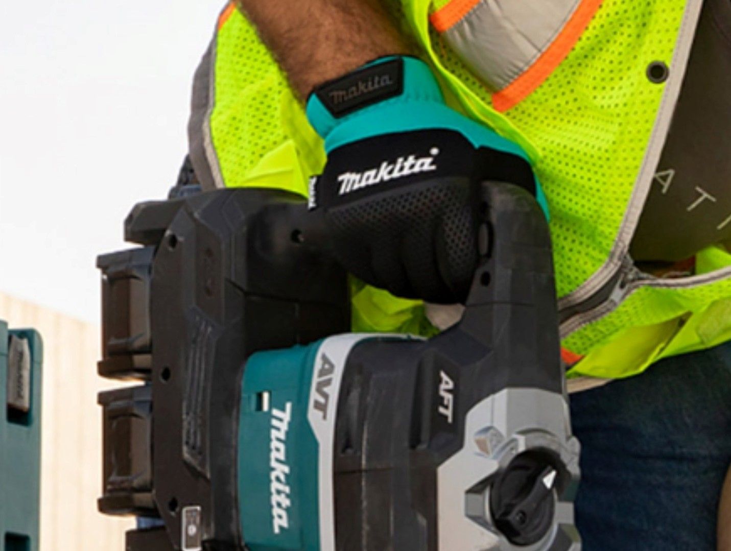 Un hombre con un chaleco amarillo sostiene una herramienta Makita.
