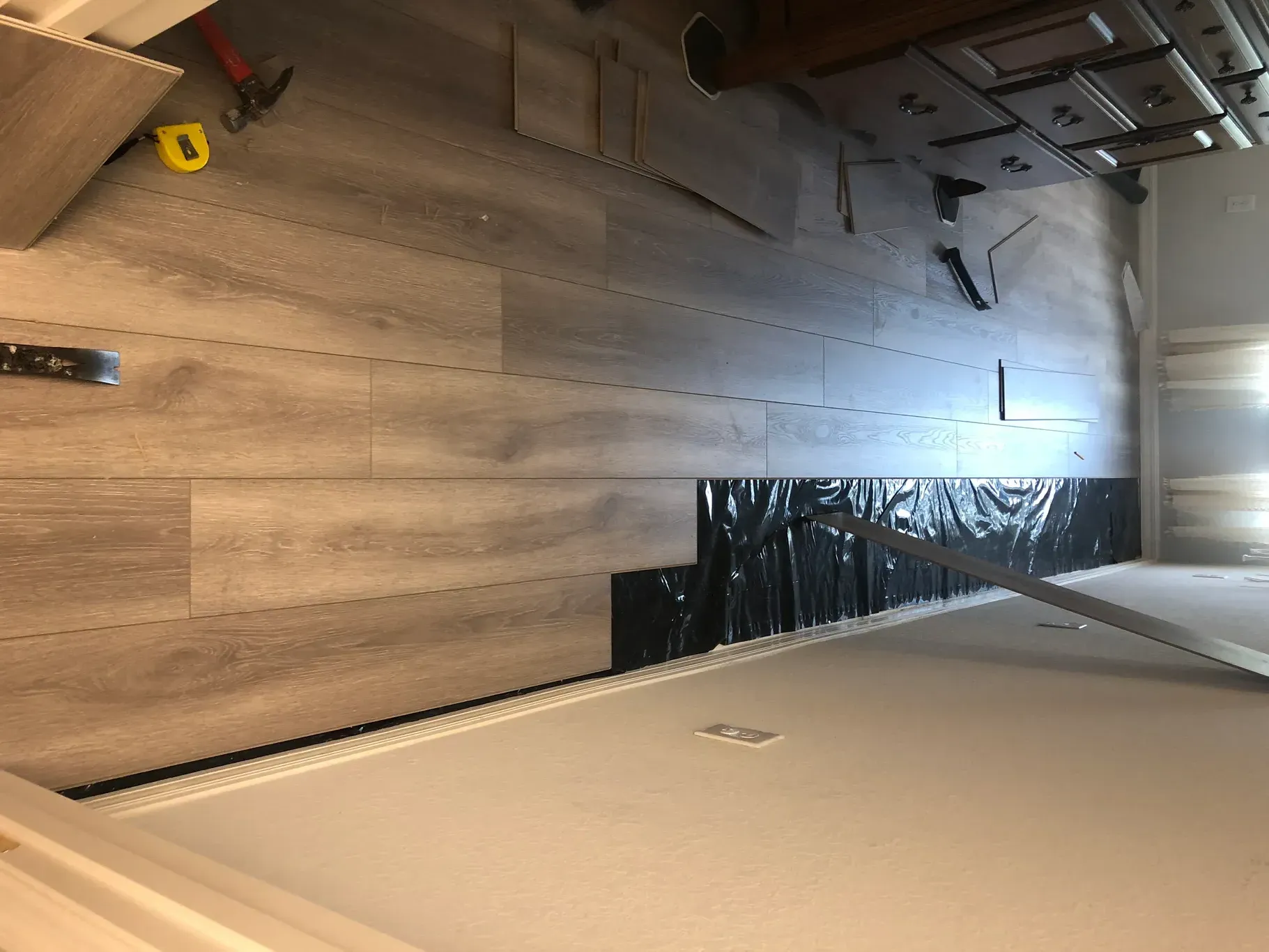 A wooden floor is being installed in a room.