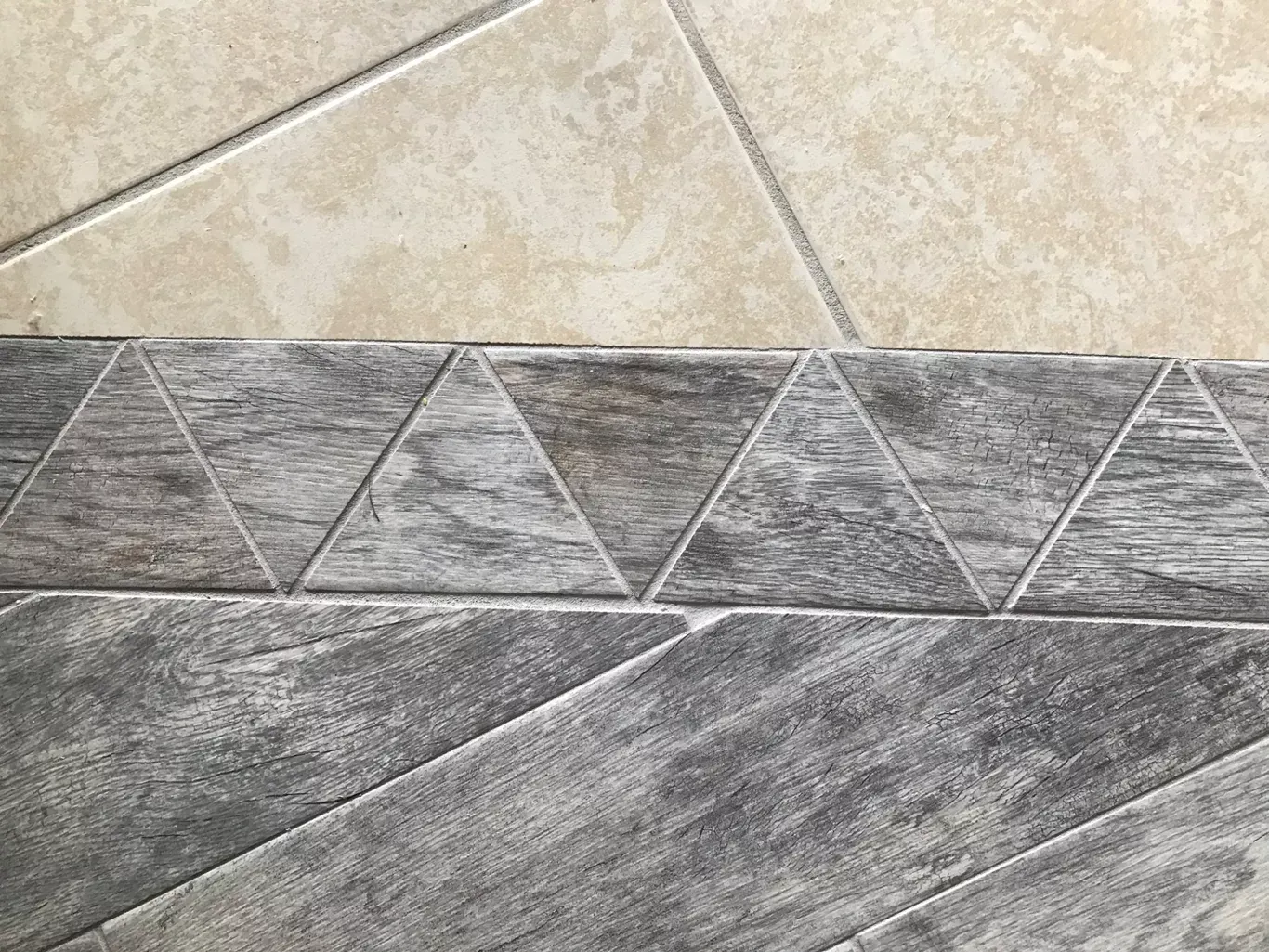 A close up of a tile floor with triangles on it.