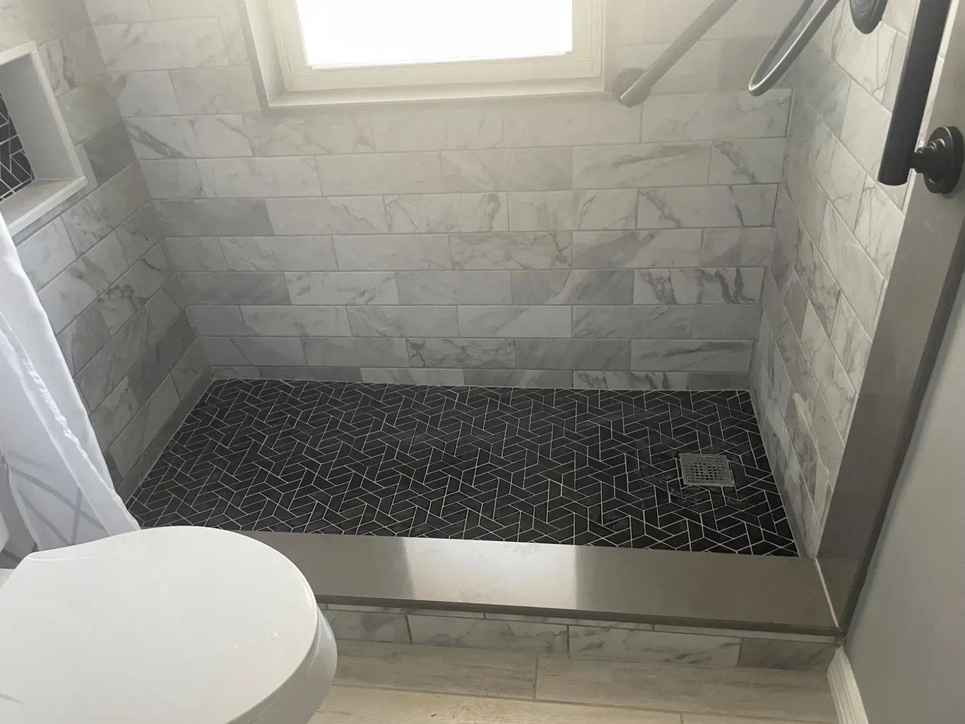 A bathroom with a walk in shower and a toilet.