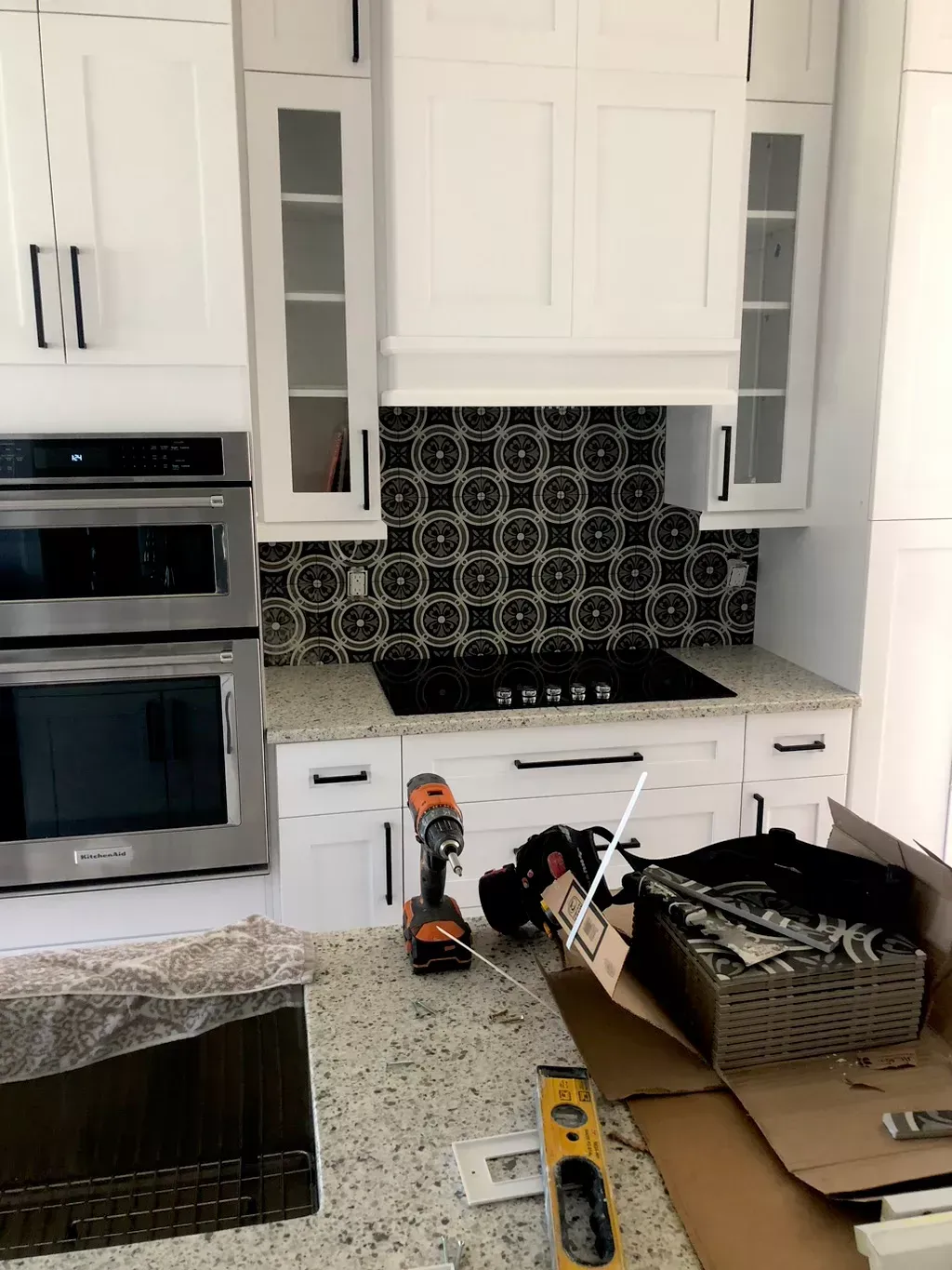 A kitchen with white cabinets and stainless steel appliances is being remodeled.