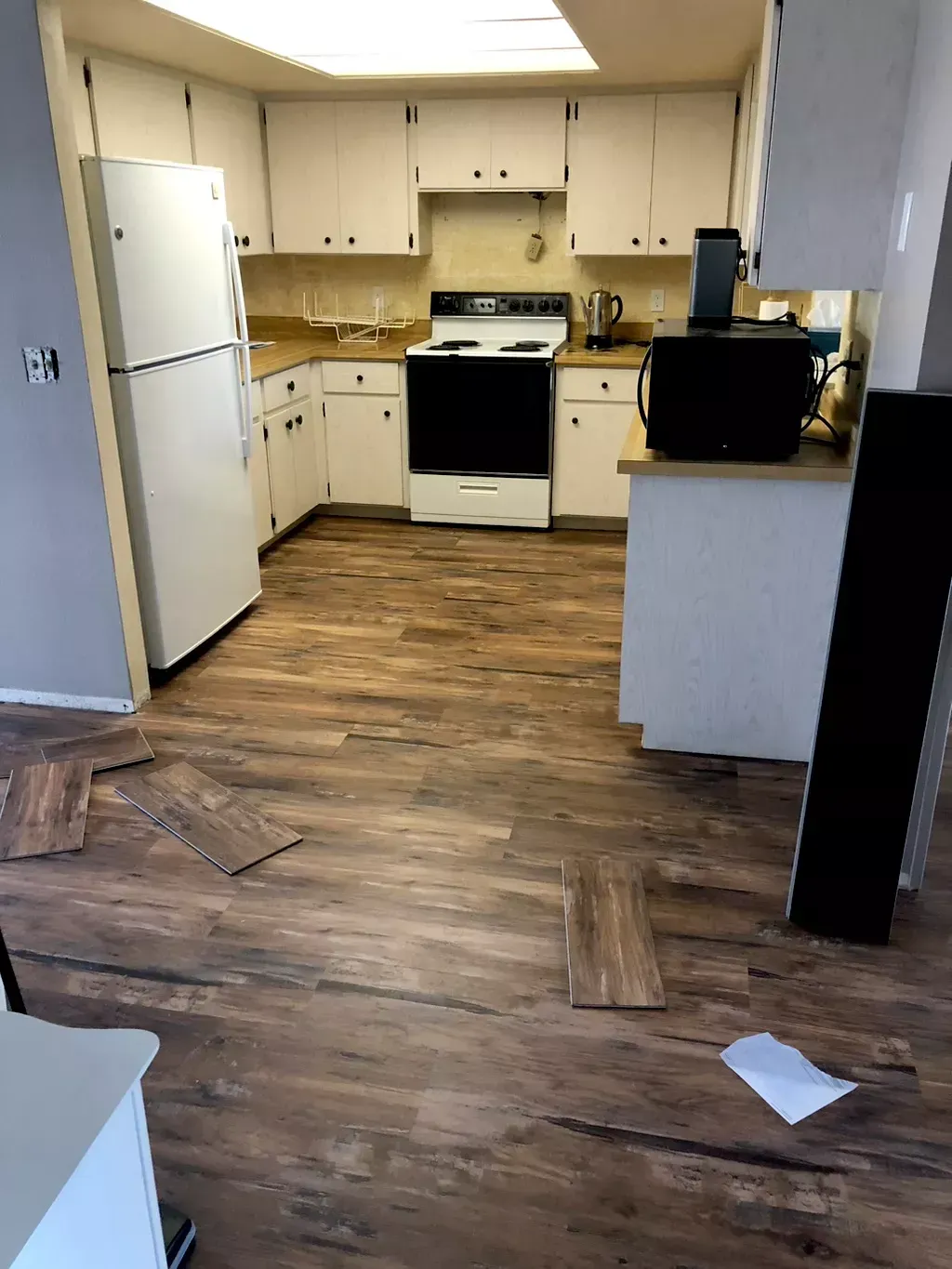 A kitchen with a wooden floor and white cabinets