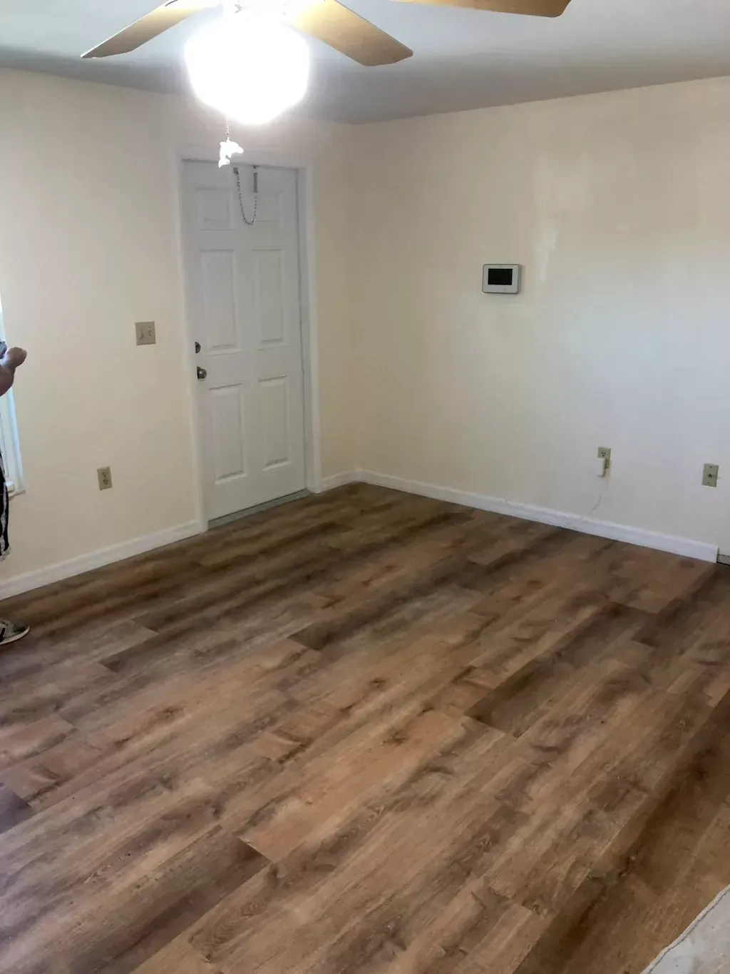 A living room with hardwood floors and a ceiling fan.