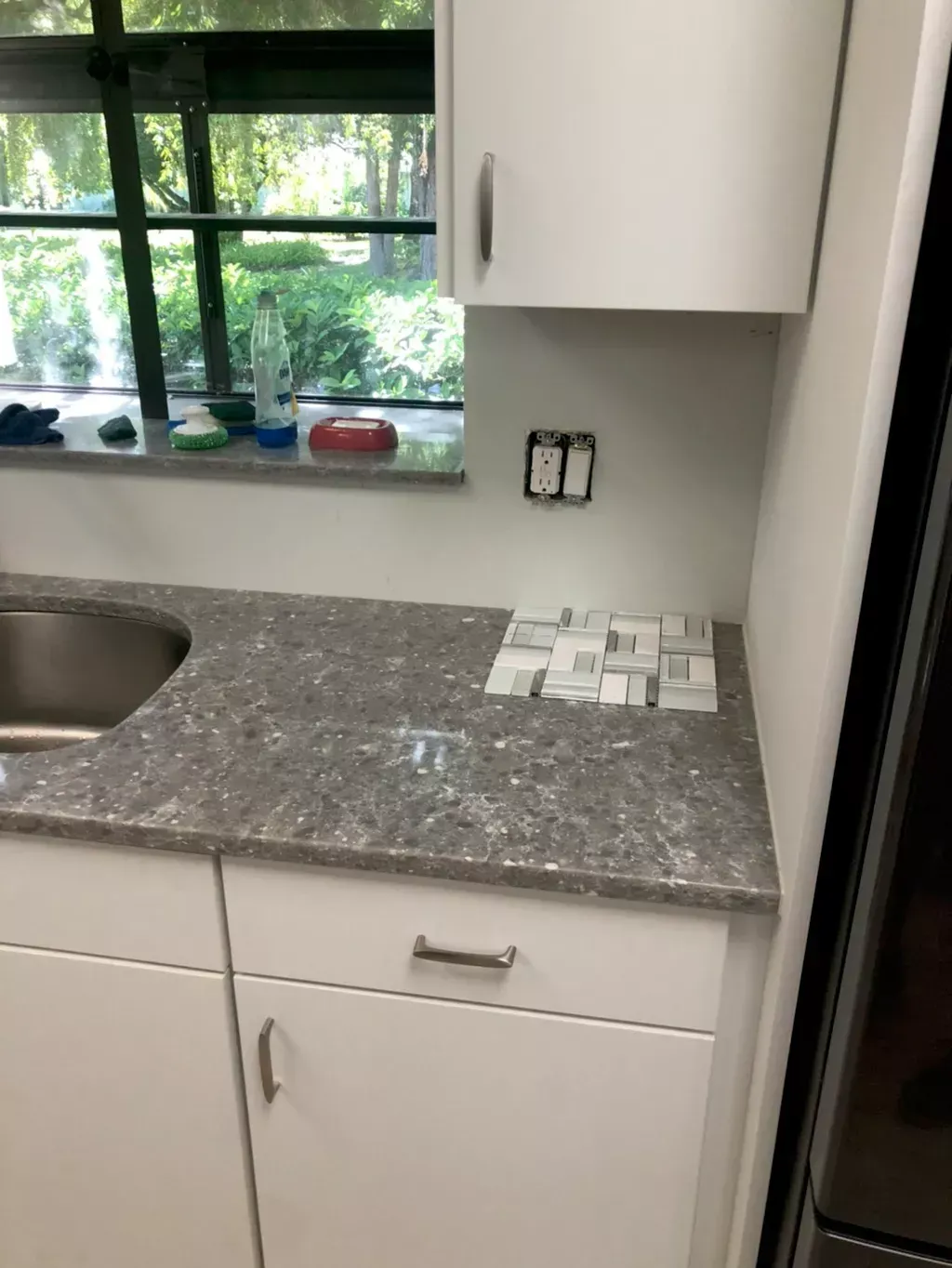 A kitchen with a sink , cabinets and a window