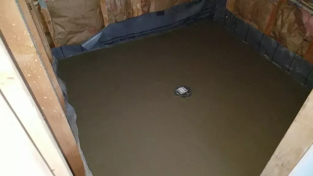 A shower stall is being built in a bathroom.