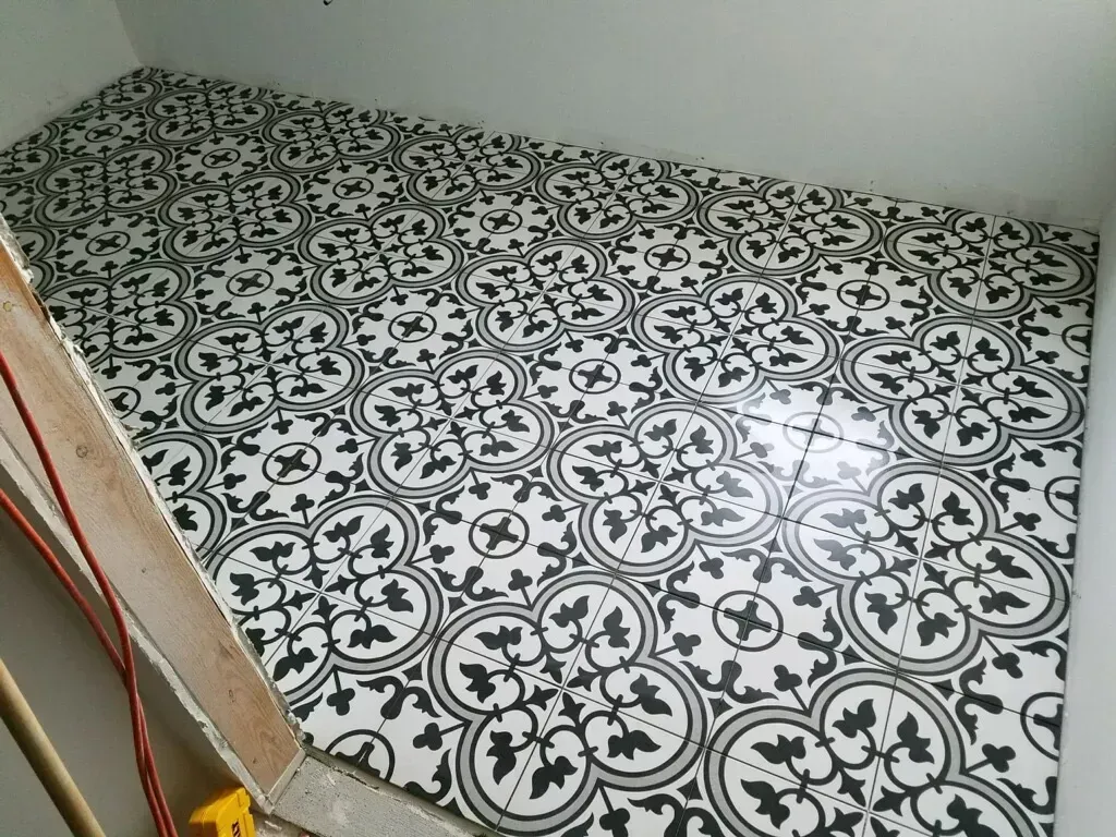 A black and white tile floor with a floral pattern.
