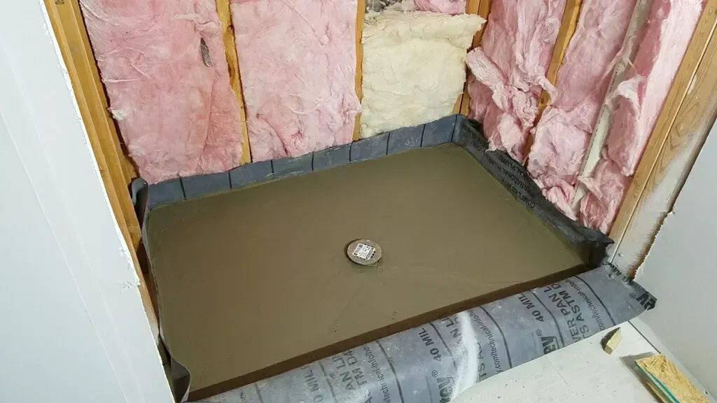 A shower stall is being built in a bathroom.