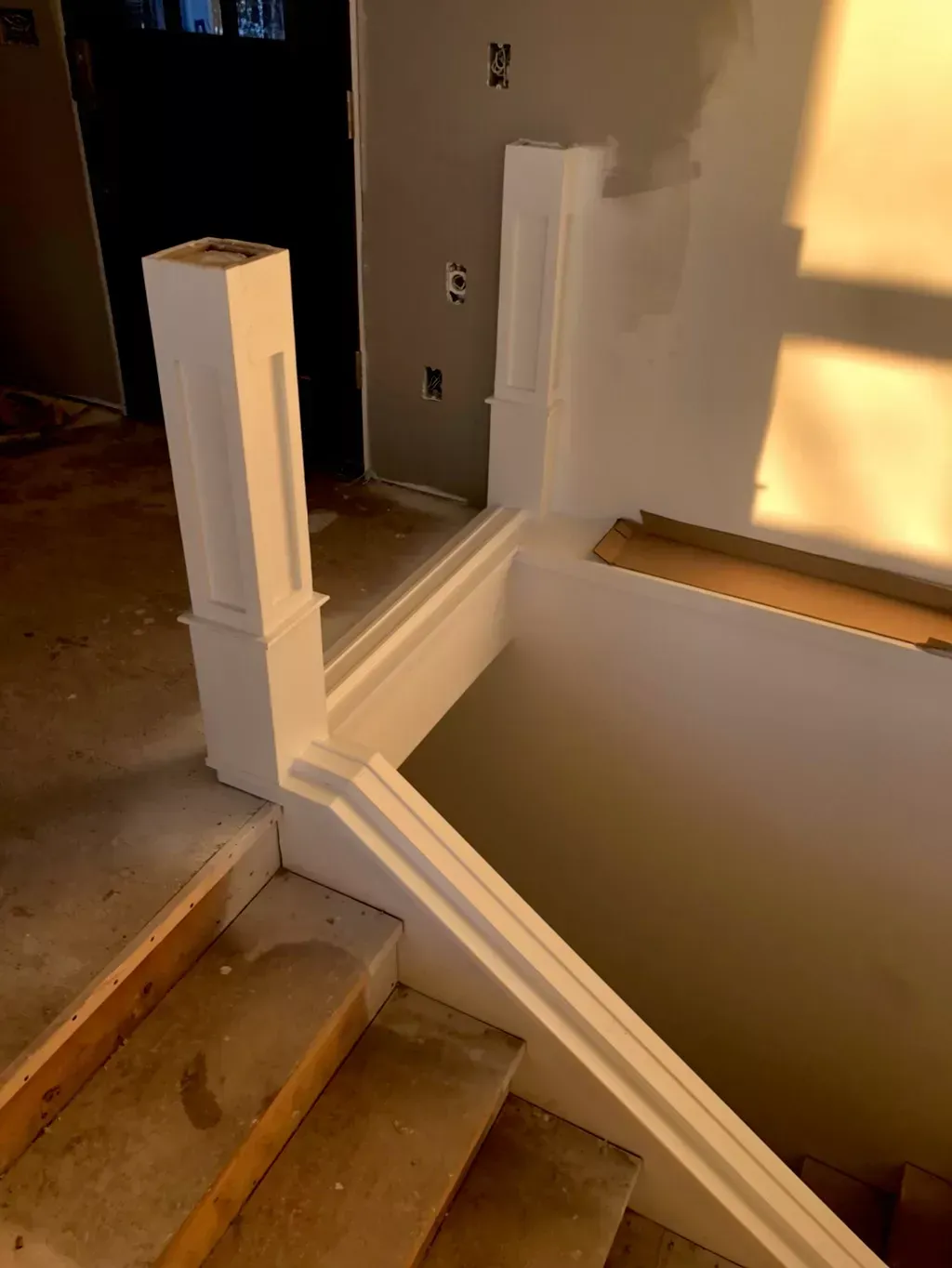 A staircase with a white railing is under construction
