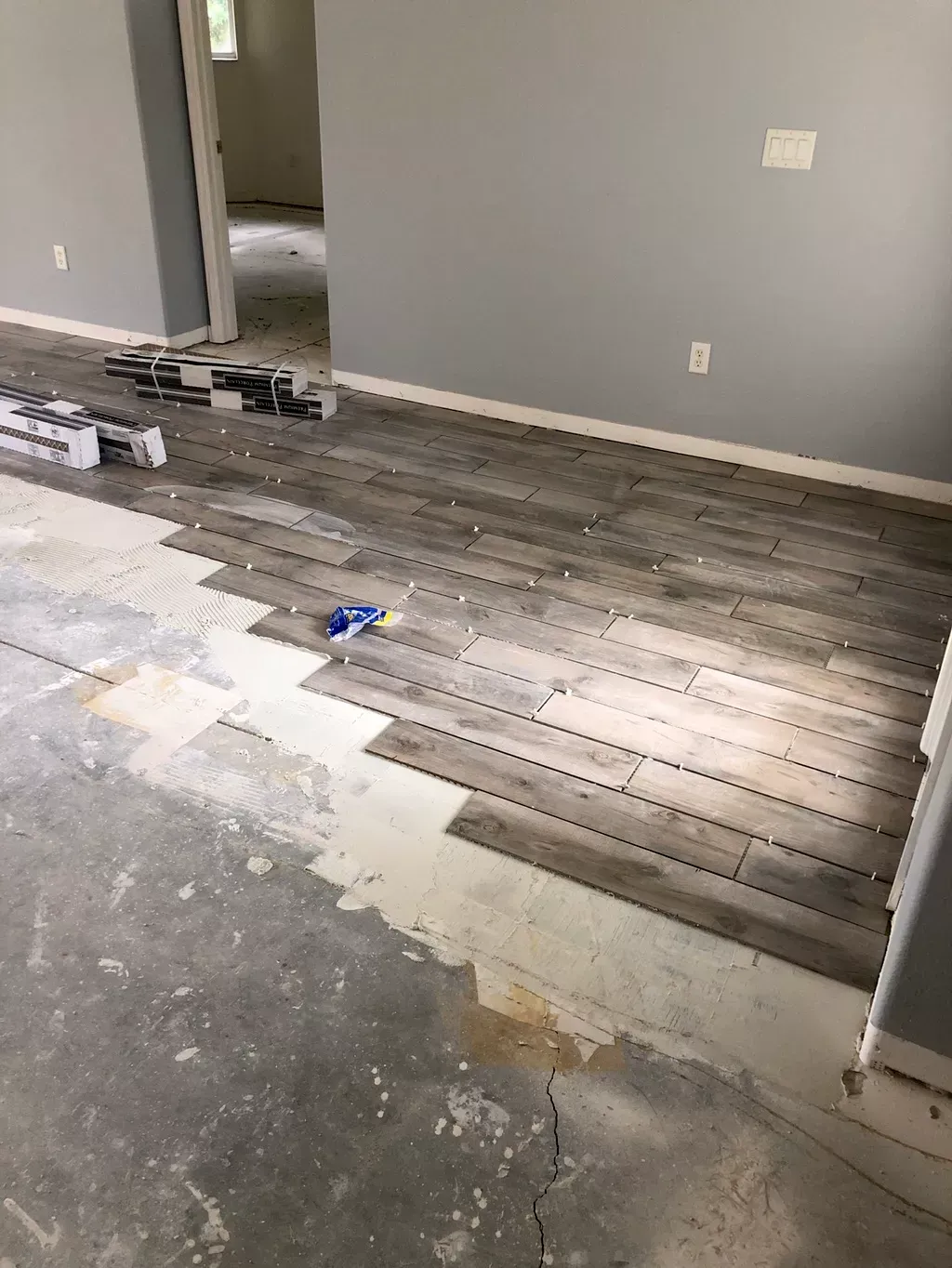 A room with a wooden floor being installed in it.