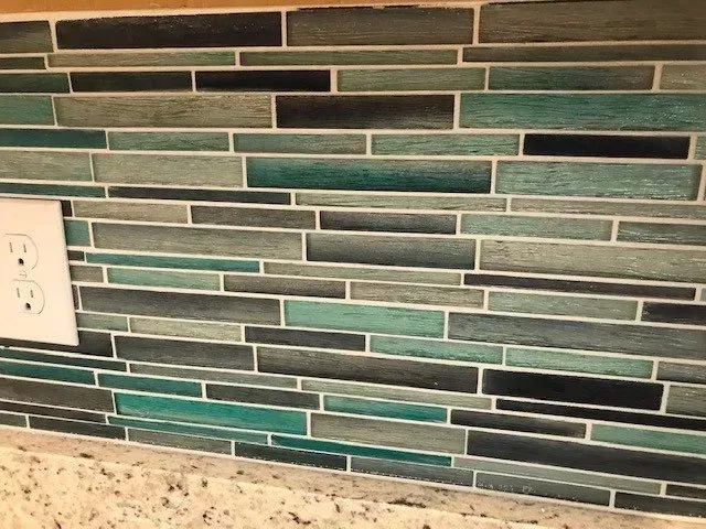 A close up of a tile wall with a socket on it.