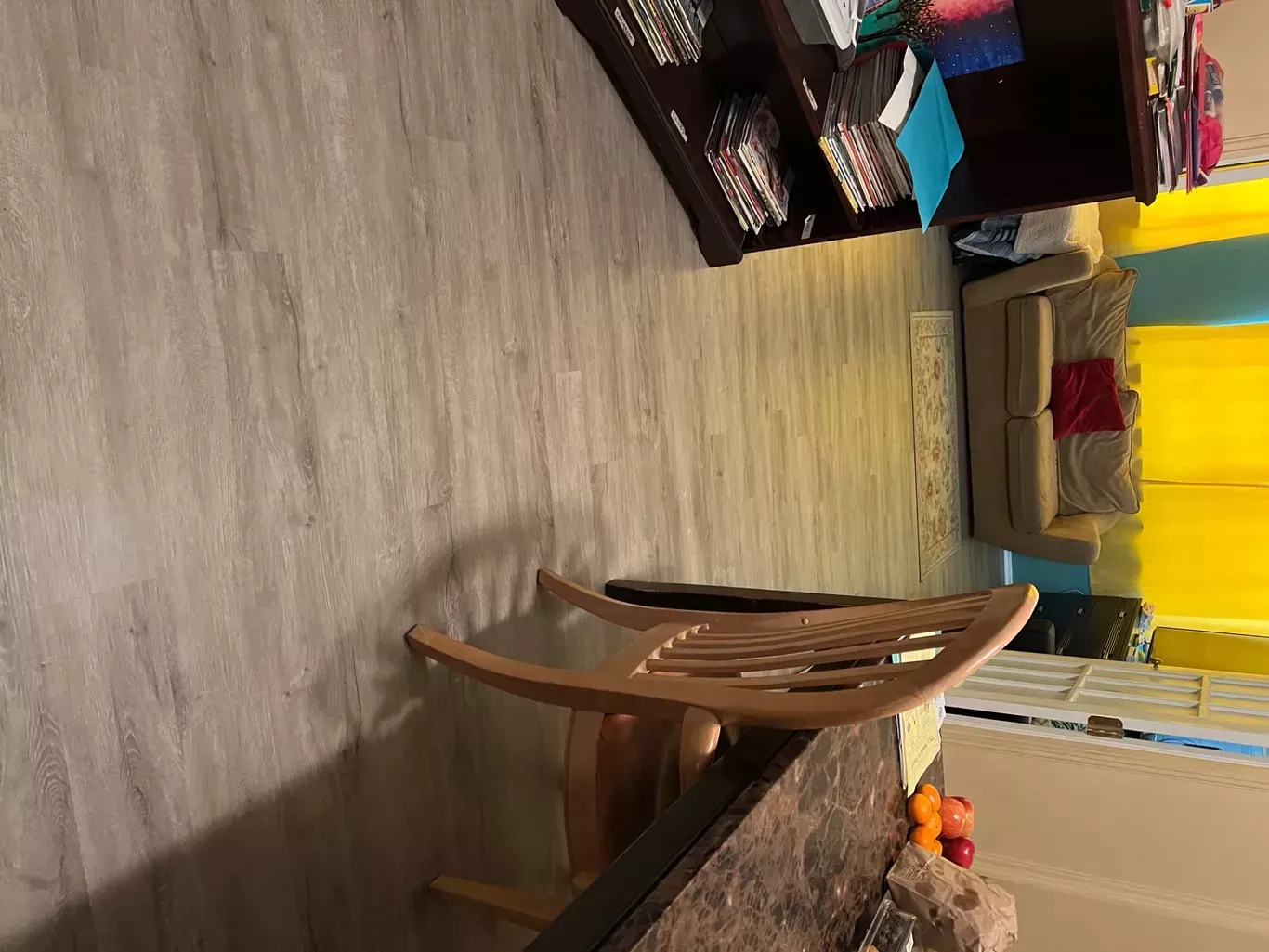 A rocking chair is sitting in a living room next to a table.