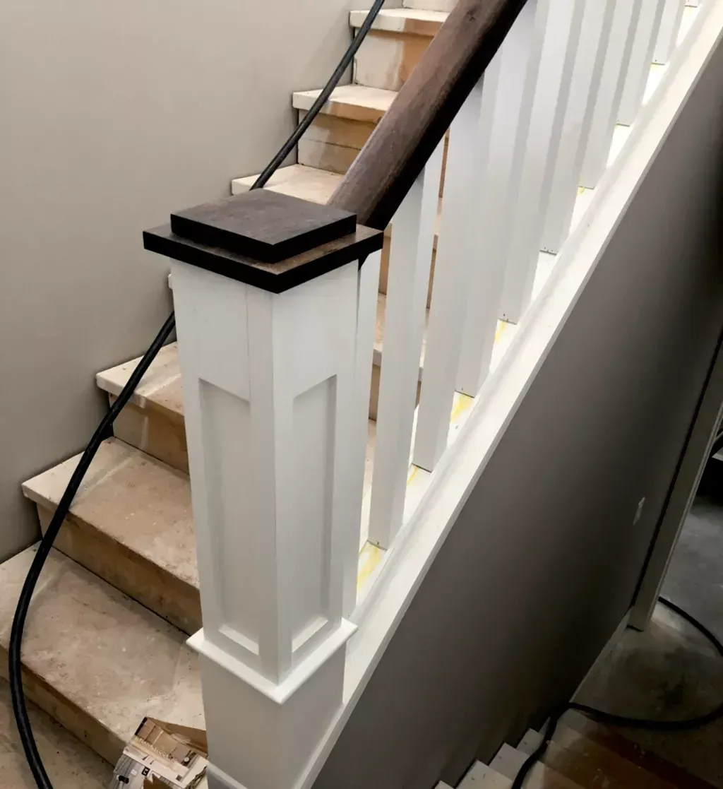A staircase with a white railing and a wooden handrail