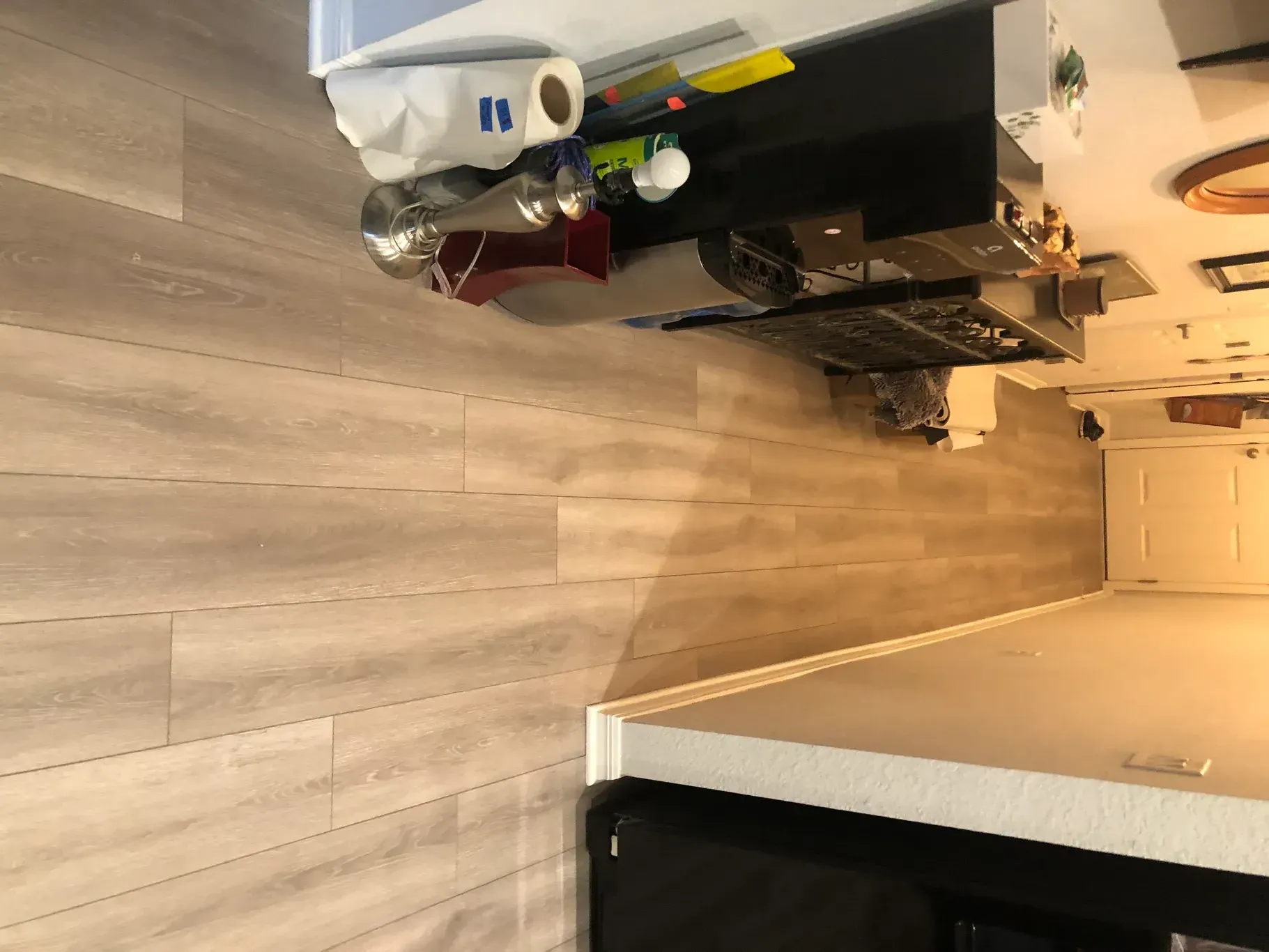 A room with a wooden floor and a table with a lot of items on it.