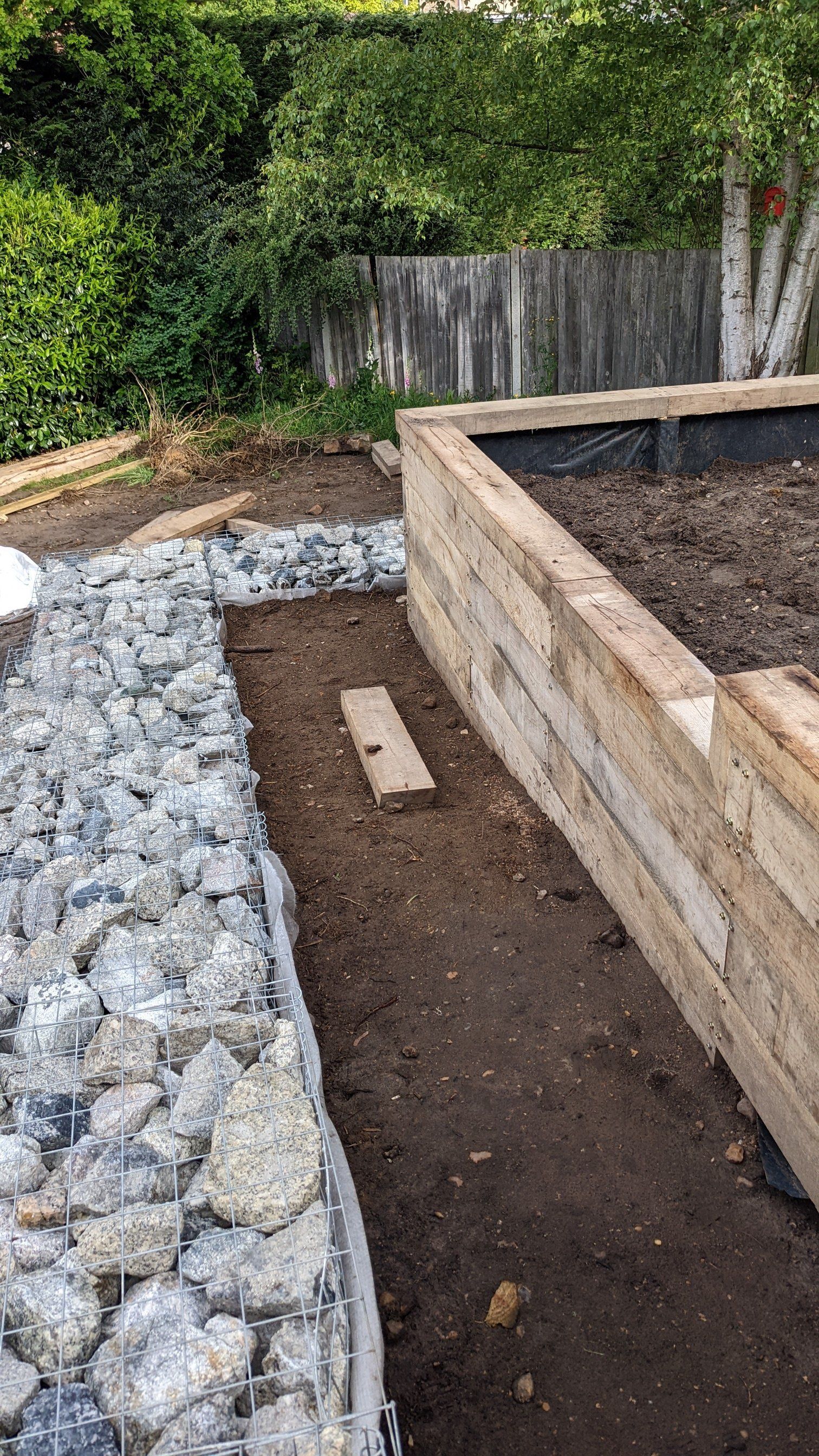 New wooden walls and stone retainer in garden