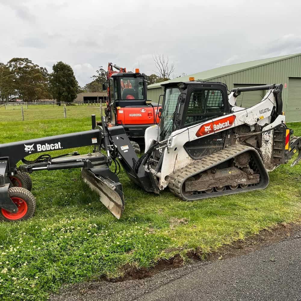 Two Bobcat Tractors Are Parked Next to Each Other on the Side of the Road — BeCivil in Nowra, NSW