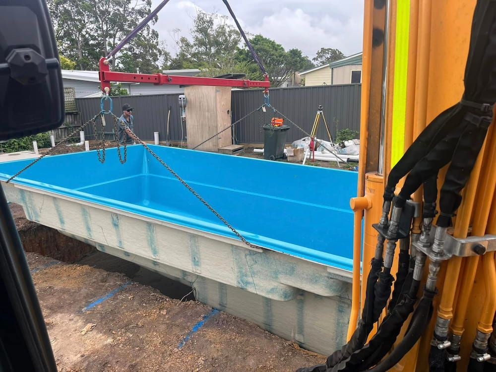 A Large Blue Swimming Pool is Being Lifted by a Crane — BeCivil in Tomerong, NSW