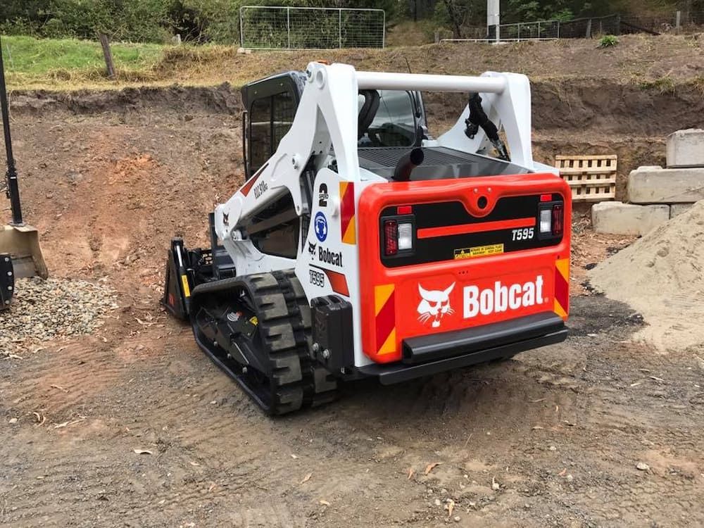 A Bobcat Tractor is Parked in a Dirt Field — BeCivil in Tomerong, NSW