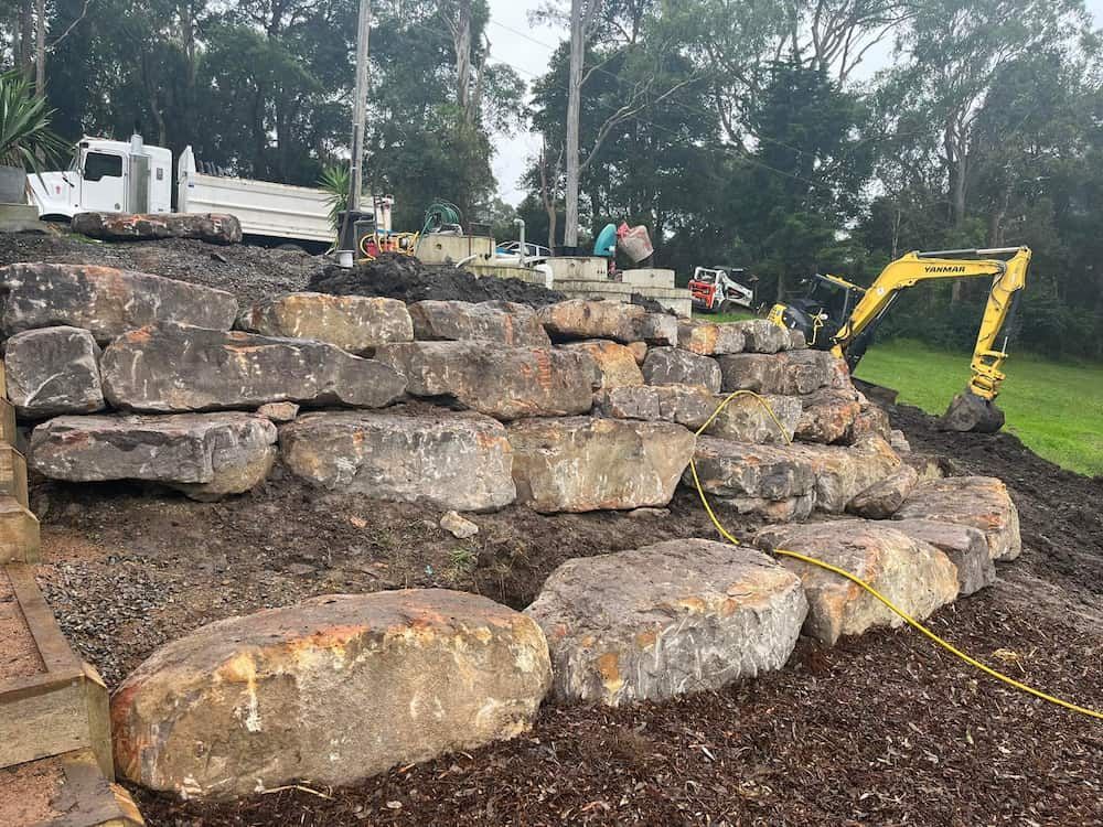 A Large Pile of Rocks is Being Built Next to a Dump Truck — BeCivil in Jervis Bay, NSW