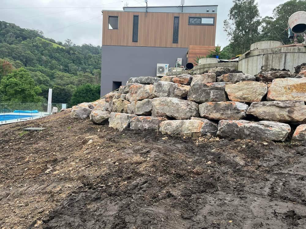 A Pile of Rocks is Sitting on Top of a Dirt Field in Front of a House — BeCivil in Nowra, NSW