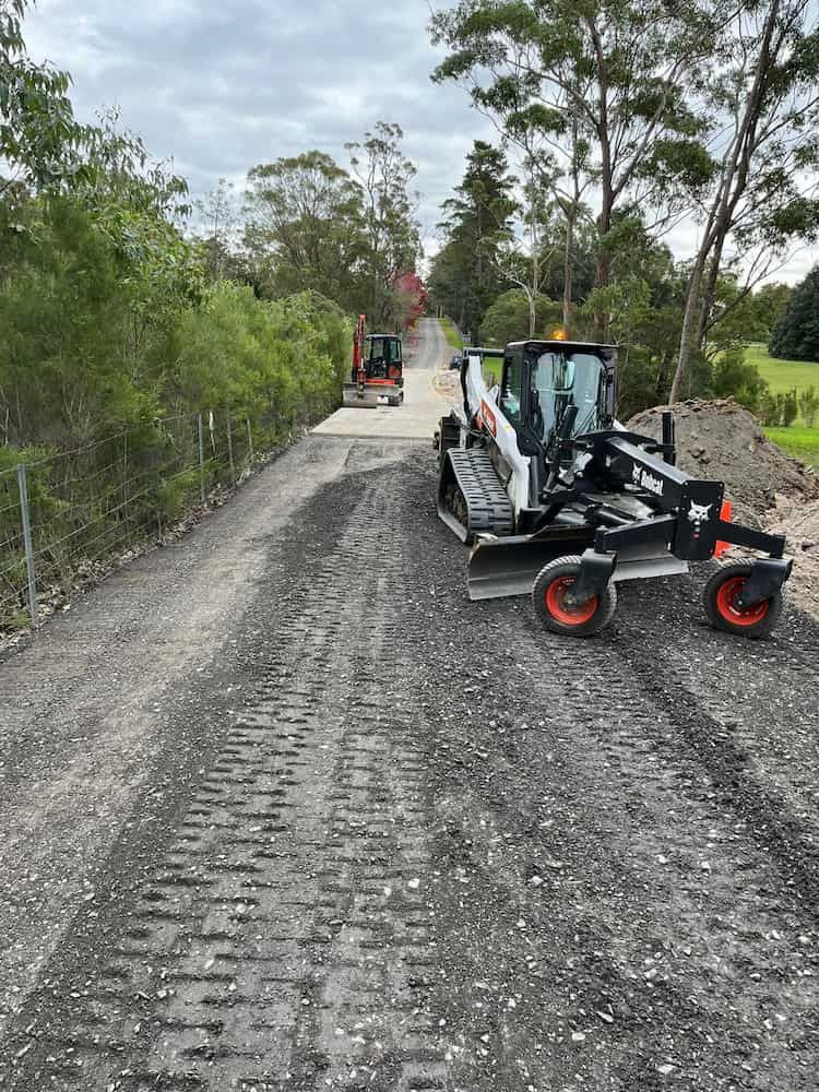 A Bulldozer is Driving Down a Dirt Road — BeCivil in Bomaderry, NSW
