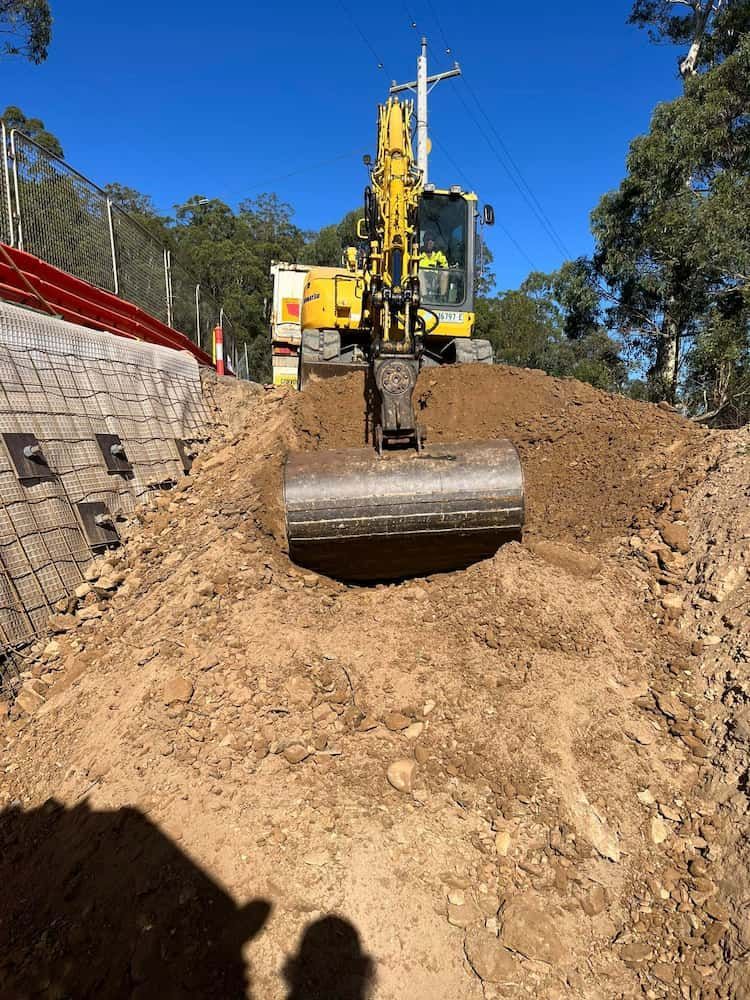 A Yellow Excavator is Digging a Hole in the Ground — BeCivil in Tomerong, NSW