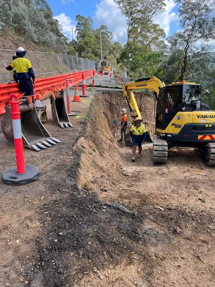 A Construction Site With a Yellow Excavator and Workers — BeCivil in Tomerong, NSW