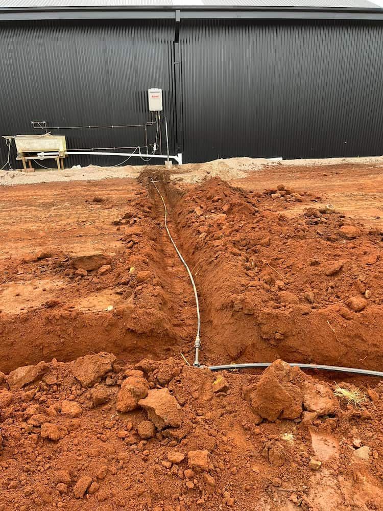 A Large Black Building is Behind a Pile of Dirt and Rocks — BeCivil in bomaderry, NSW