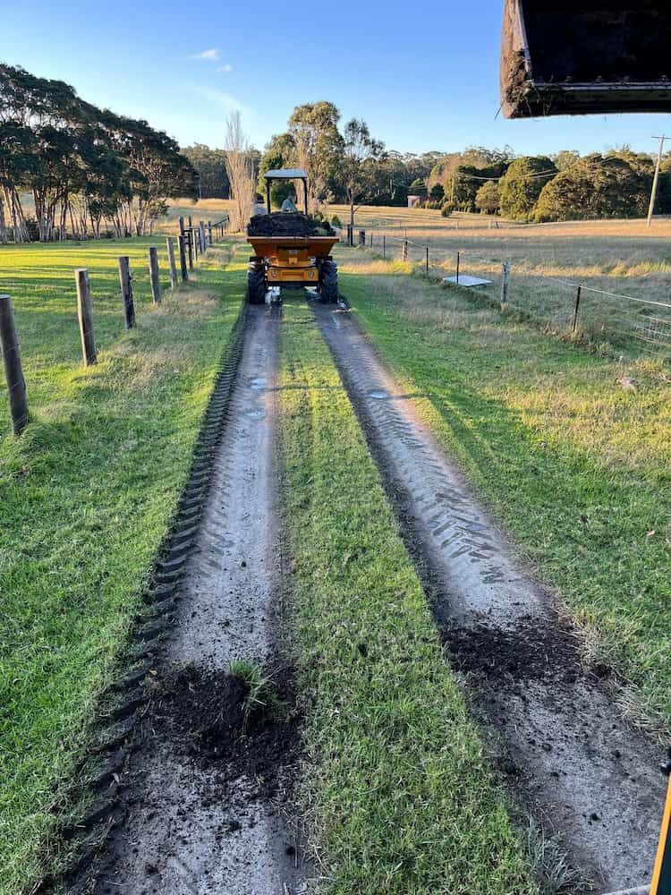 A Tractor is Driving Down a Muddy Road in a Field — BeCivil in Berry, NSW
