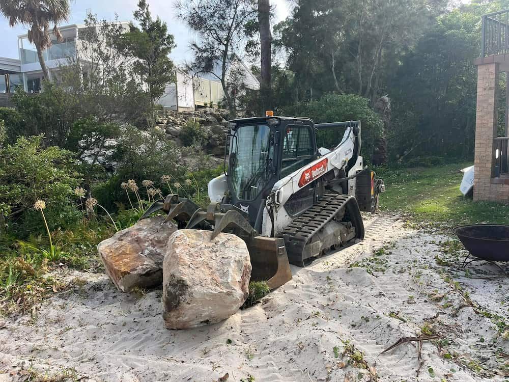 A Bulldozer is Moving Rocks in a Yard — BeCivil in Huskisson, NSW