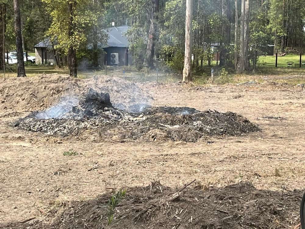A Pile of Dirt Surrounded by Flames in the Center of a Grassy Field — BeCivil in Nowra, NSW