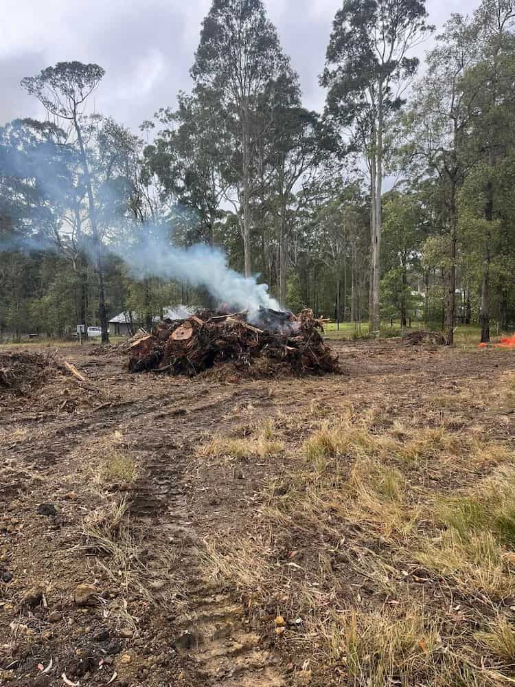 A Pile of Logs in a Field With Smoke Coming Out of Them — BeCivil in Jervis Bay, NSW