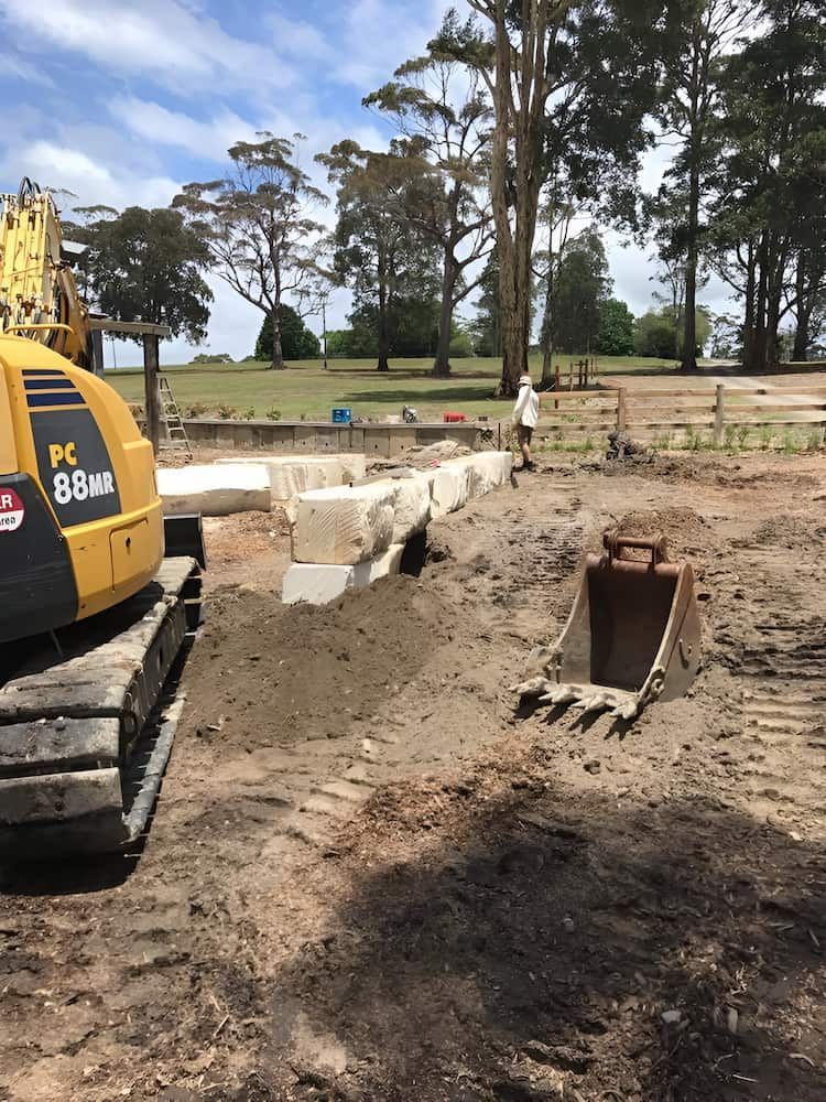 A Yellow and Black Excavator is Sitting on Top of a Dirt Field — BeCivil in Jervis Bay, NSW