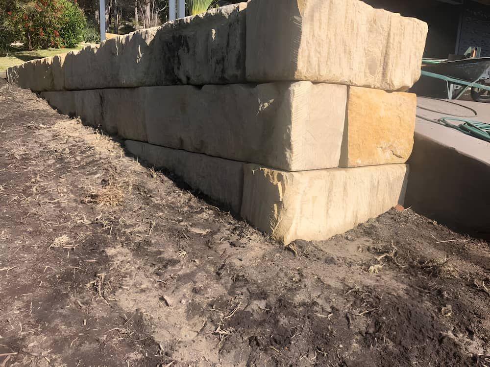 A Large Stone Wall is Sitting on Top of a Dirt Field — BeCivil in Berry, NSW